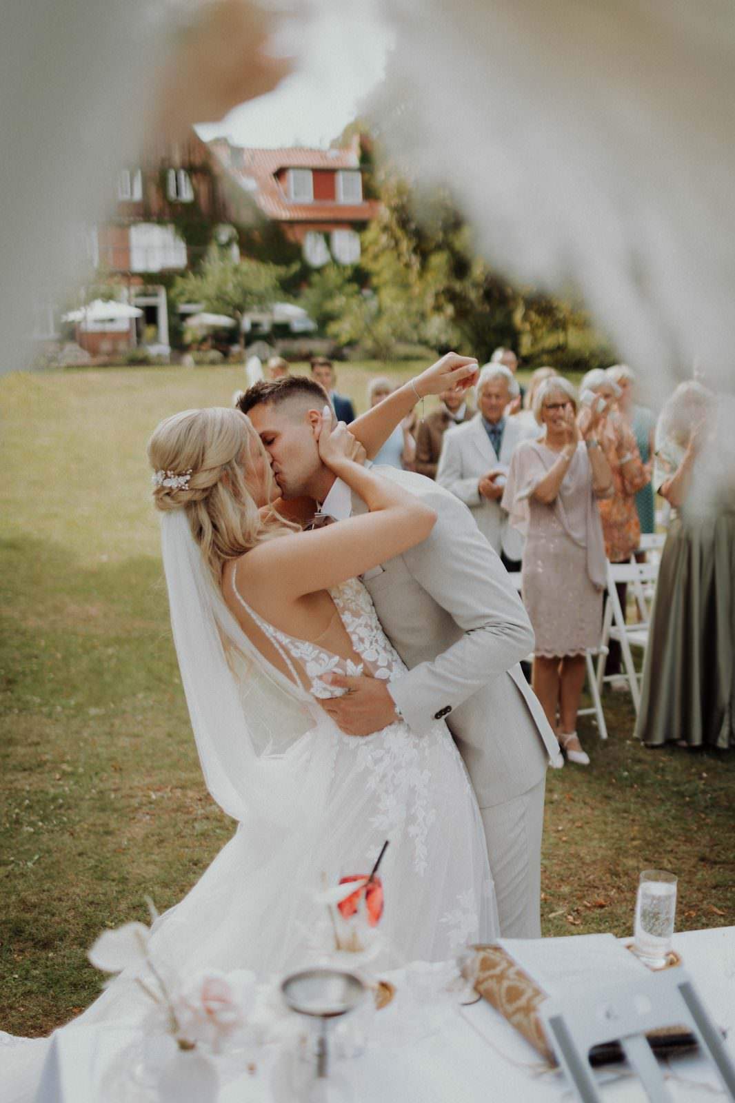 Hochzeitsfotograf Mölln — Cyana und Basti, Kuss beim Auszug am Pampasgras-Altar, Hotel Waldhof