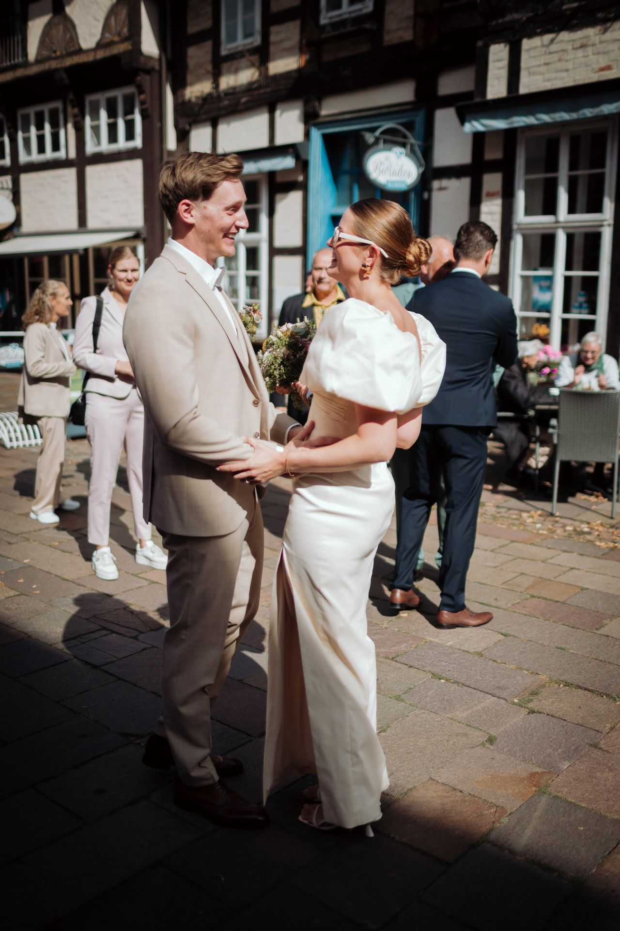 Jana und Sören lachen zusammen vor dem Fachwerkhaus