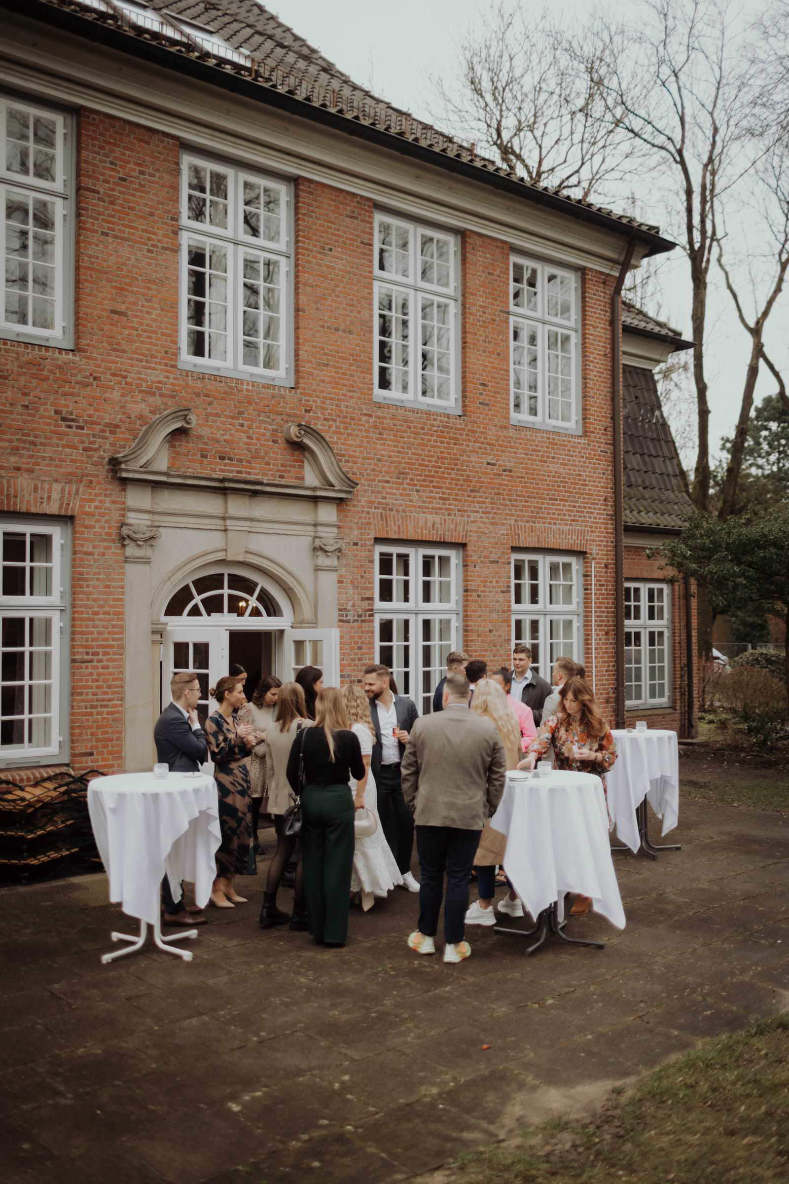 Die Gäste trinken Aperitif und essen kleine Snacks im Garten des Stavenhagenhauses
