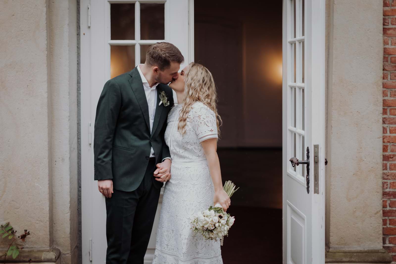 Alina und Hauke küssen sich beim Paarportrait im Garten des Stavenhagenhauses